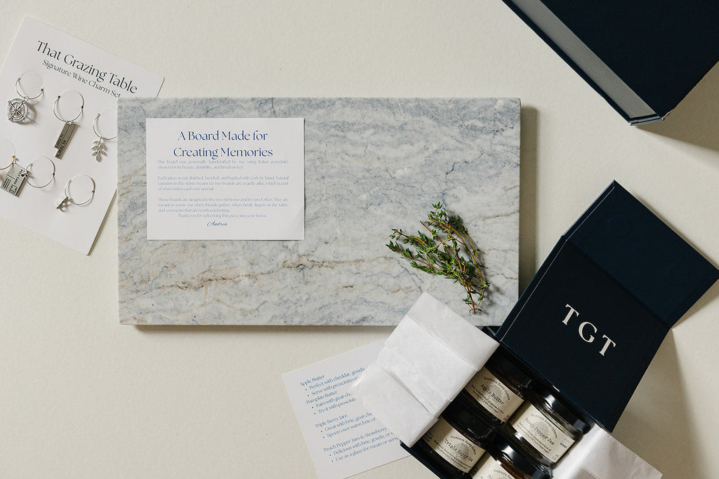 Aleutian Signature Set: handcrafted marble charcuterie gift set with artisan jams, wine charms, and navy keepsake box from That Grazing Table