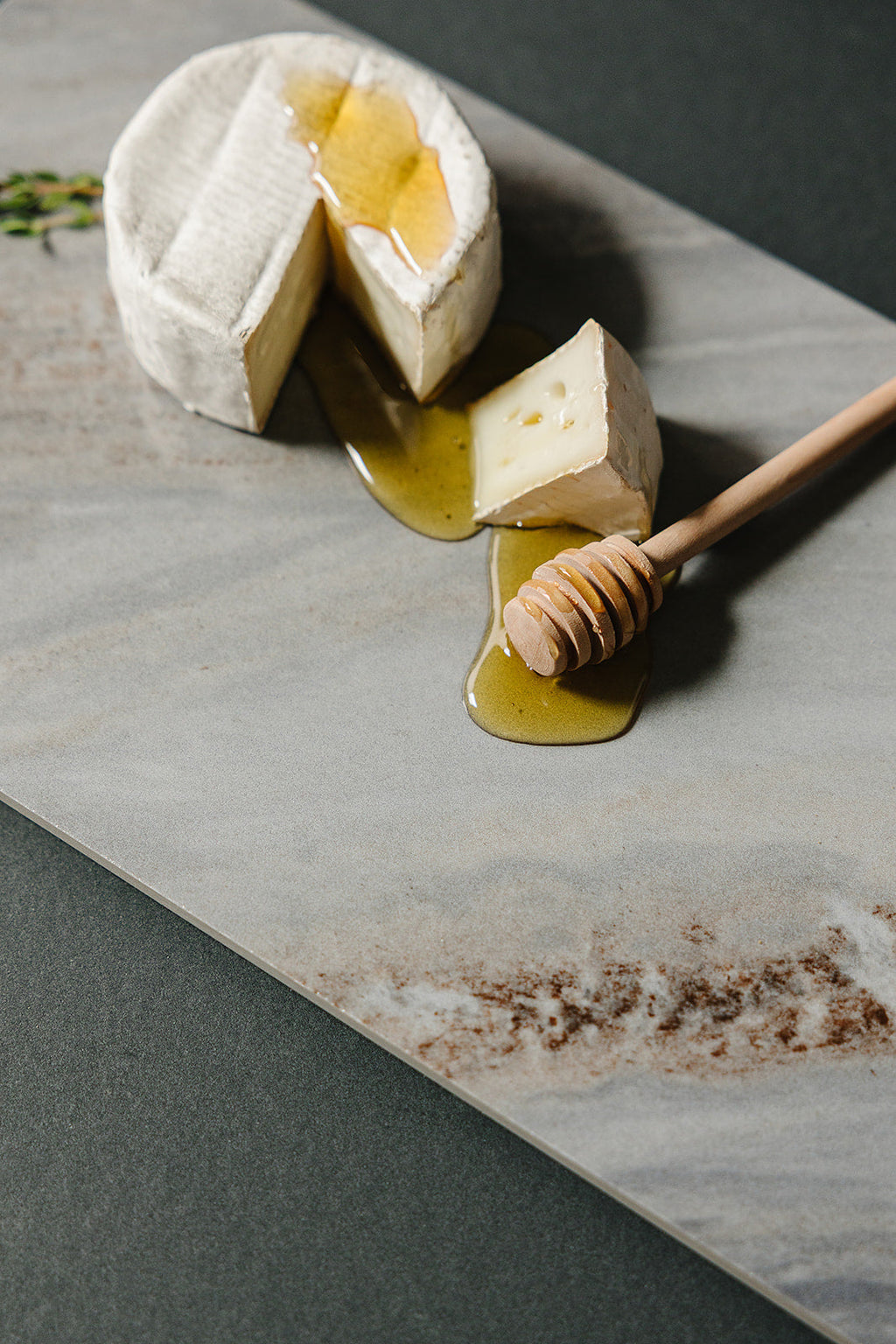 Close-up of Cortina gray natural stone Italian porcelain charcuterie board styled with artisan provisions
