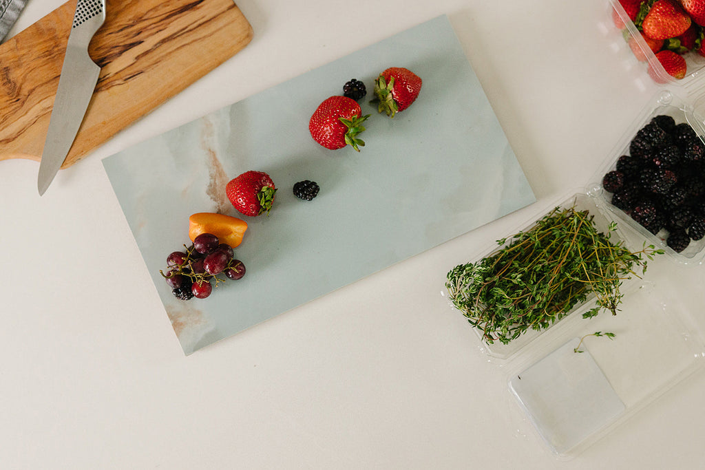 Sage-green Verona porcelain charcuterie board styled with fresh fruit for entertaining