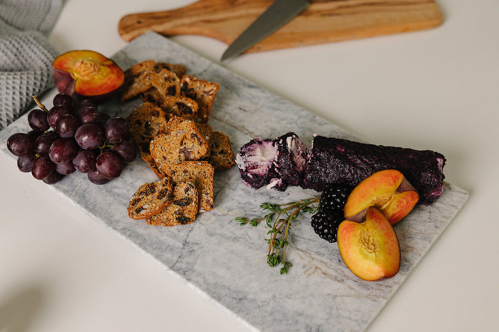 Aleutian marble charcuterie board styled lifestyle with cheese, crackers, and fresh fruit
