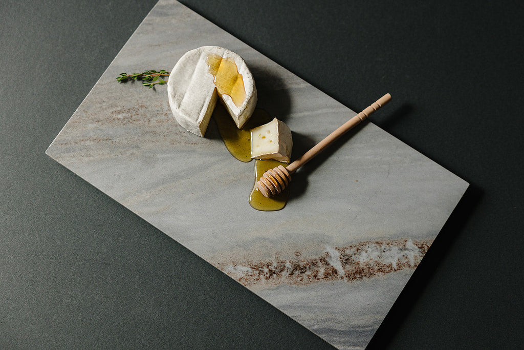 Cortina porcelain charcuterie board styled with cheese and honey for entertaining