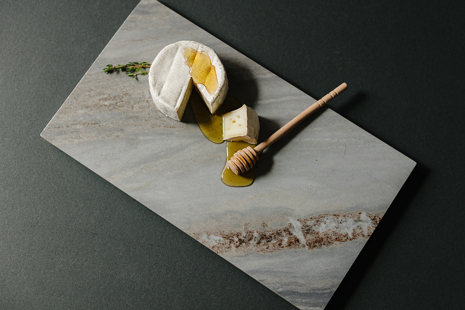 Cortina gray natural stone Italian porcelain charcuterie board styled with cheese and honey for client gifting