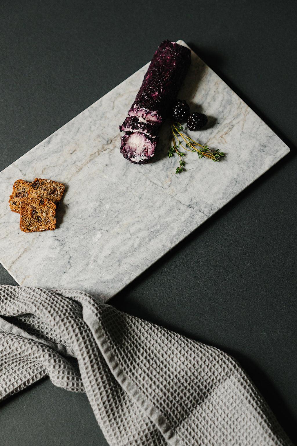 Handcrafted marble charcuterie board with goat cheese, crackers, and honey - Aleutian Collection