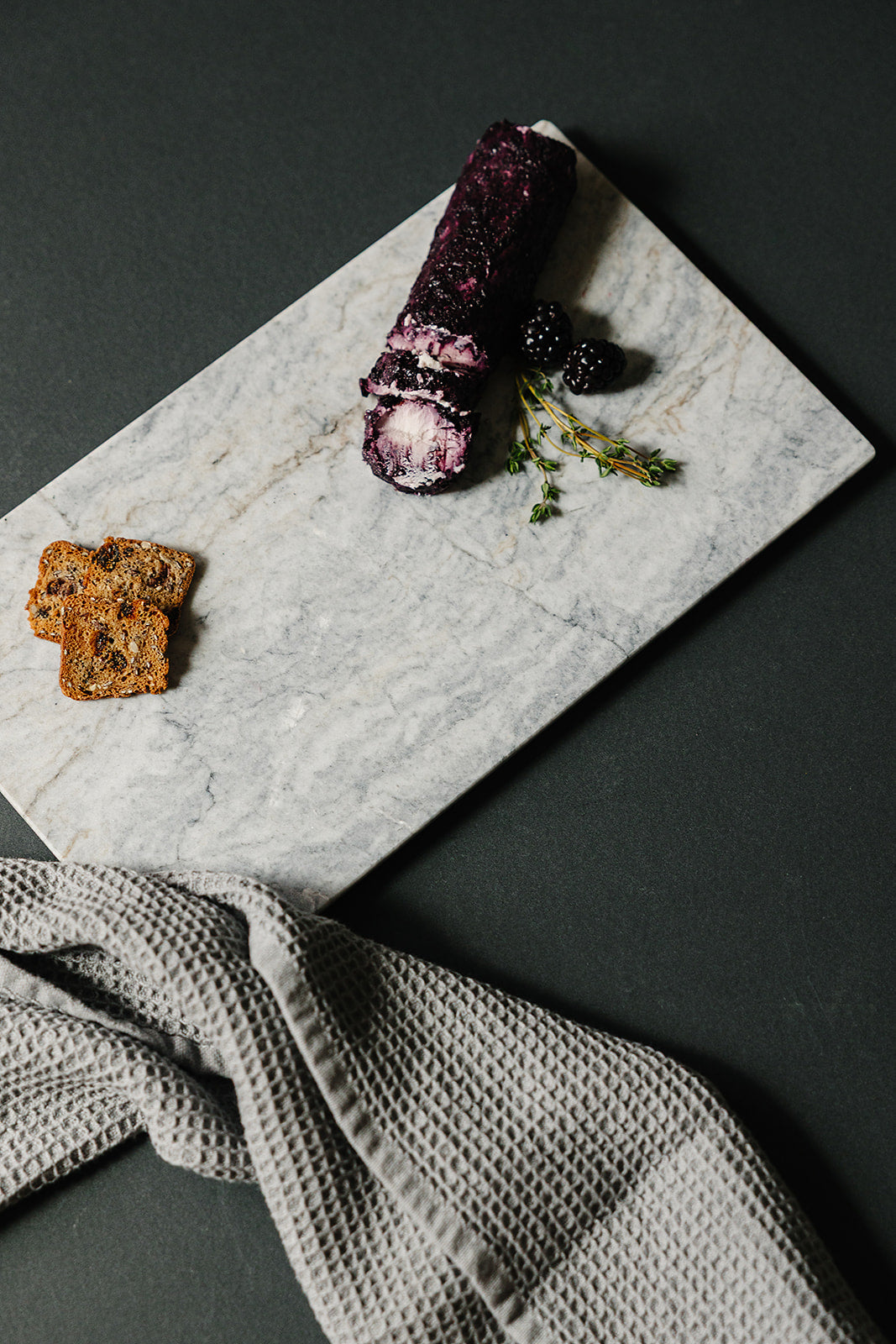 Handcrafted marble charcuterie board with goat cheese, crackers, and honey - Aleutian Collection
